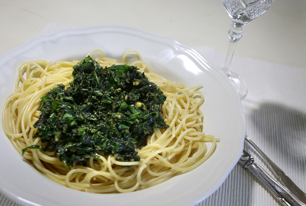 Maukasta vuohenputkipestoa keitetyn spaghetin päällä valkoisella lautasella