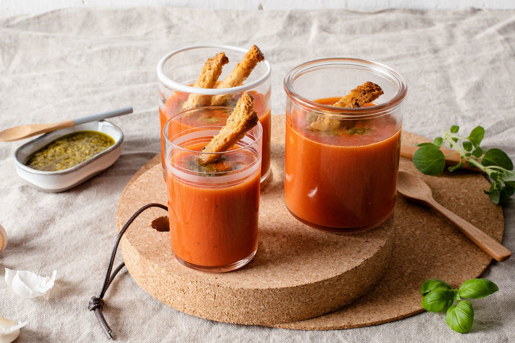 Maukas kylmä tomaattikeitto lasissa koristeltuna krutongeilla