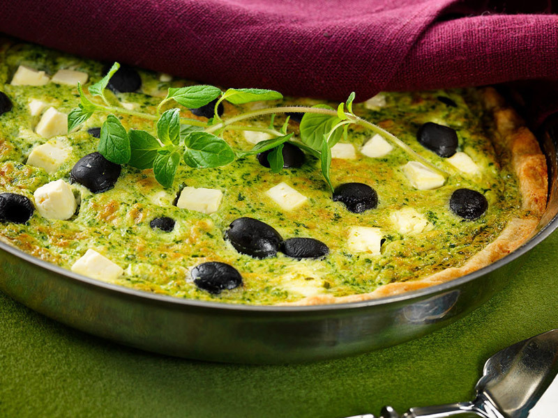 Helppo ja herkullinen kreikkalainen feta-pinaattipiirakka valmiina tarjoiltavaksi hopeisessa piirakkavuoassa