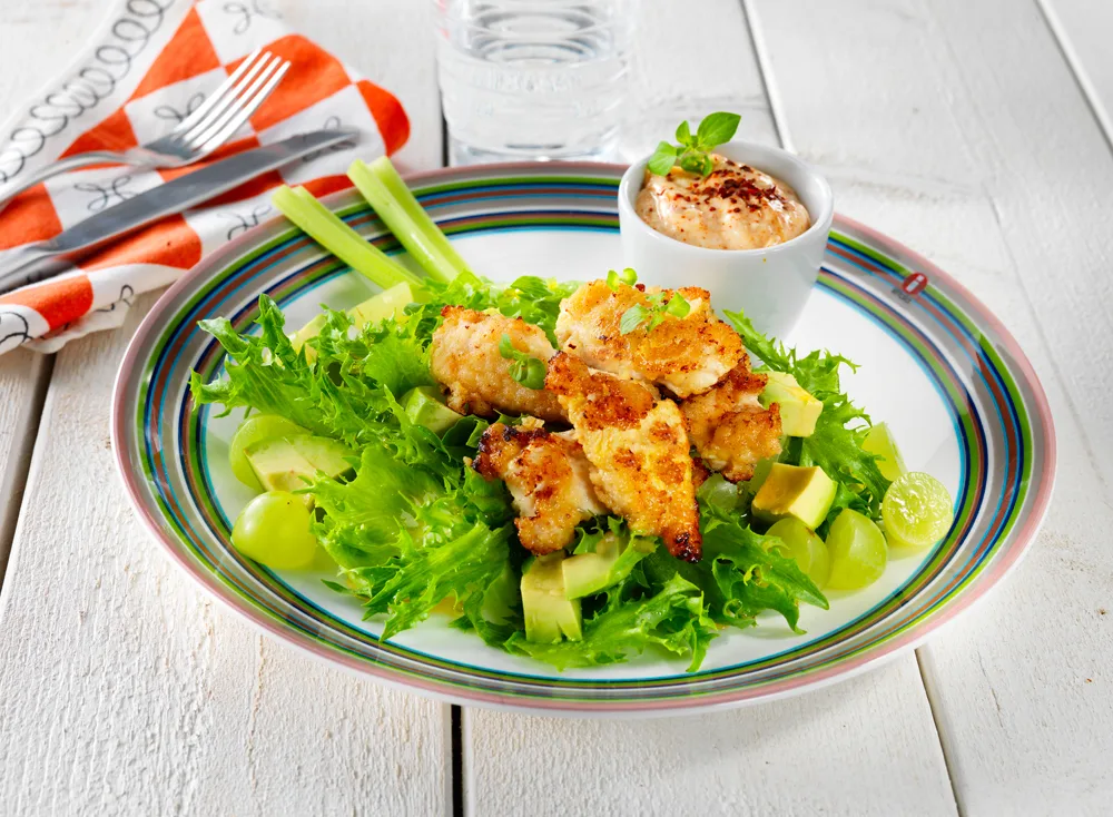 Sitruunaiset broilernugetit vihreällä salaattipedillä ja lempeän tulisella majoneesilla lautasella ruokapöydässä